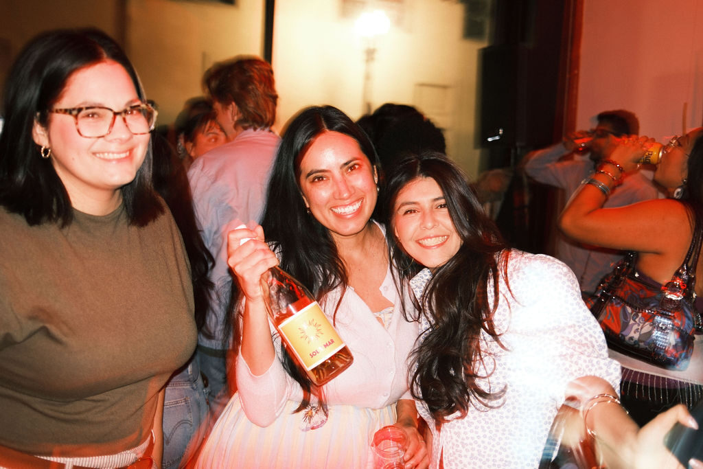 Friends holding a bottle of Sol y Mar rosé